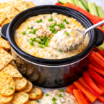 easy crockpot crab dip with cream cheese and green onions in a small slow cooker with chips and vegetables