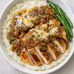 French onion chicken mashed potato bowl with sliced chicken, caramelized onion gravy, and green beans over creamy mashed potatoes in a white bowl