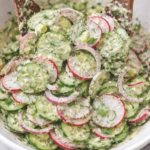 green goddess cucumber salad with radishes and red onion tossed in creamy herb dressing