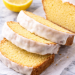 Thick slices of glazed lemon loaf cake styled on wrinkled parchment paper