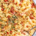 Creamy southern pimento cheese mac and cheese with bacon and crispy breadcrumb topping in a skillet on a marble countertop