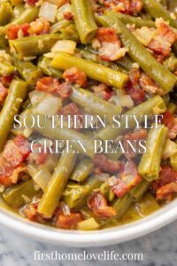 Southern style green beans with bacon and onions in a white bowl with rich broth on a marble countertop