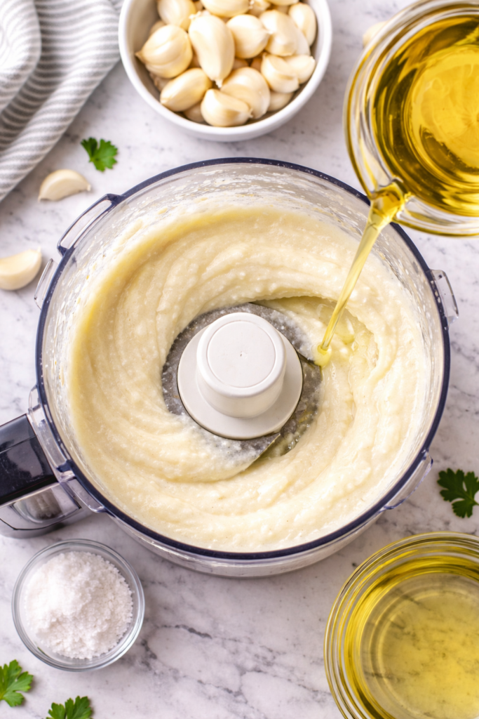 Step by step toum garlic sauce emulsifying with oil drizzle