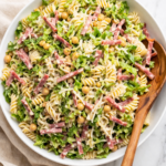 La Scala chopped pasta salad with rotini, salami, chickpeas, romaine, and pecorino in a white bowl on marble counter