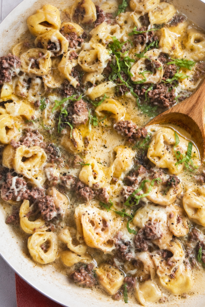 Garlic butter beef tortellini skillet with cheesy tortellini, ground beef, and rich buttery garlic sauce in a white skillet