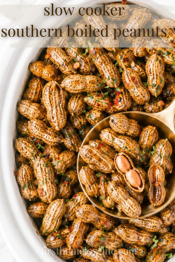 Slow cooker Southern boiled peanuts in a white crockpot with a gold spoon on a marble countertop