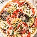 This unbaked old-fashioned tomato pie is layered with juicy heirloom tomatoes, sweet onions, fresh herbs, and cheese inside a flaky homemade crust.