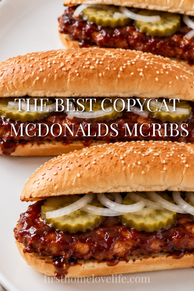 Copycat McDonald's McRib sandwiches topped with BBQ sauce, pickles, and onions on sesame seed buns.