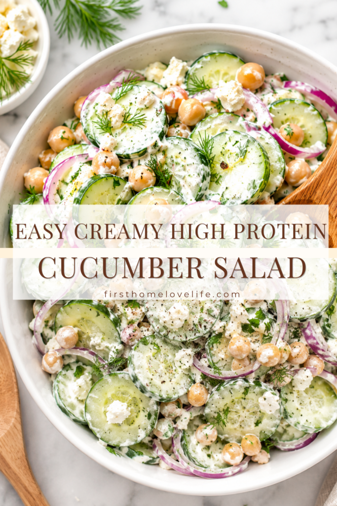 Easy creamy high protein cucumber salad made with cucumbers, chickpeas, feta cheese, red onions, fresh dill, and Greek yogurt dressing in a white serving bowl.