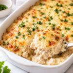 French onion chicken and rice casserole baked with caramelized onions, creamy rice, tender chicken, and melted Gruyere cheese in a white casserole dish.