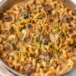 Creamy Bloomin' Onion steak bite pasta made in one pan with tender seared steak bites, cavatappi pasta, caramelized onions, crispy fried onions, and a rich, cheesy cream sauce.
