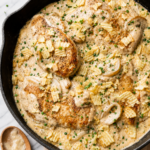One pan sour cream and onion chicken topped with crushed potato chips and fresh chives in a creamy onion sauce.
