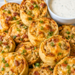 Crispy chicken bacon ranch tortilla pinwheels with ground chicken, bacon, melted cheddar, and green onions served with ranch dressing.