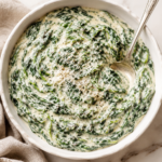 Creamed spinach with nutmeg, Parmesan and black pepper in a white serving bowl