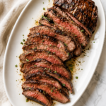 Sliced medium-rare churrasco steak made with a copycat Texas de Brazil marinade served on a white platter.