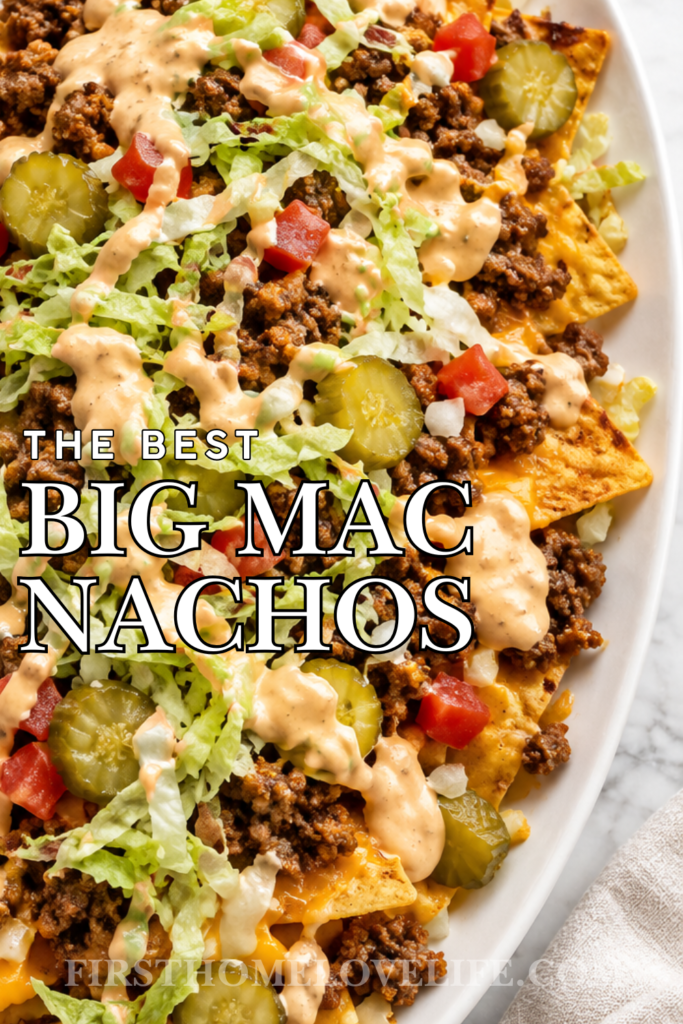 Big Mac nachos topped with seasoned ground beef, cheese, pickles, lettuce, tomatoes, and creamy burger sauce on a white oval platter.