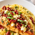 Carrabba’s Chicken Bryan copycat served over creamy lemon noodles with goat cheese, sun-dried tomatoes, basil, and lemon butter sauce