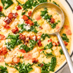 Creamy Tuscan white bean and kale soup with bacon in a white enamel Dutch oven.