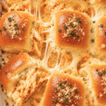 Garlic Parmesan buffalo chicken wing dip sliders with creamy orange chicken filling, melted cheese, celery, parsley, and buttery garlic-Parmesan rolls.