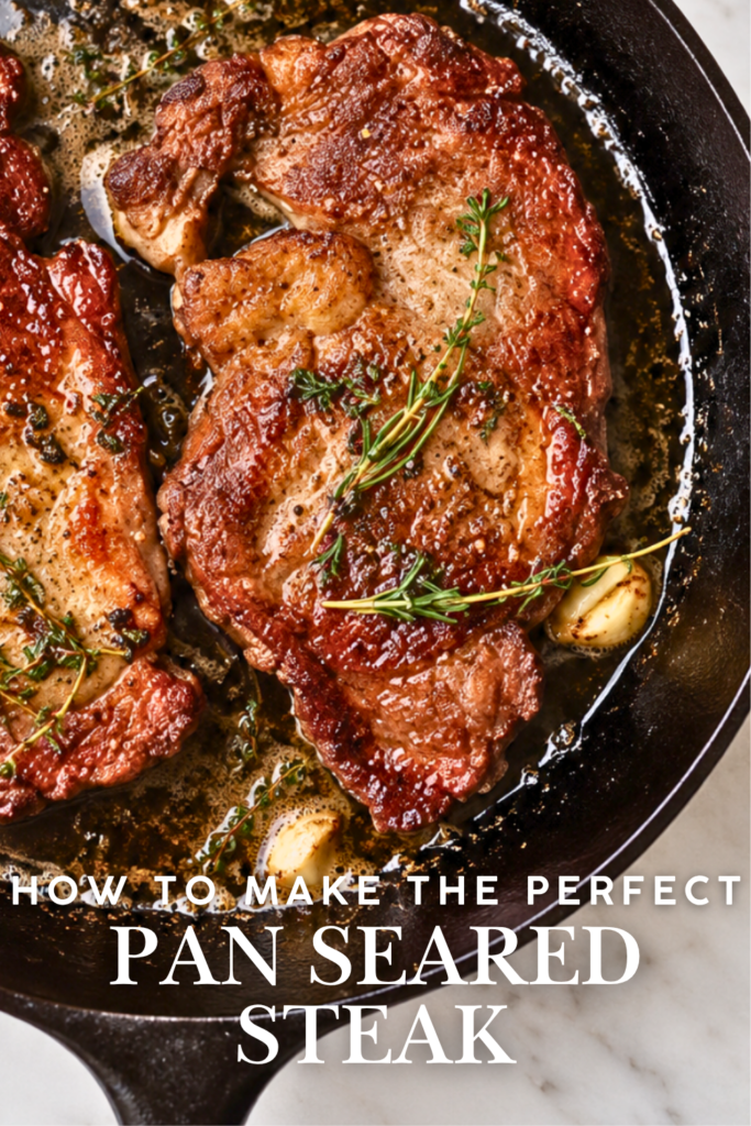 Garlic butter pan seared steak in a cast iron skillet with rosemary and thyme.
