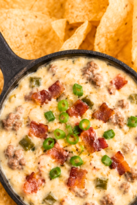 Jalapeño popper bacon hamburger white queso dip in a cast-iron skillet surrounded by tortilla chips