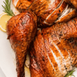 Sliced Thanksgiving smoked turkey with rosemary and lemon on a white platter
