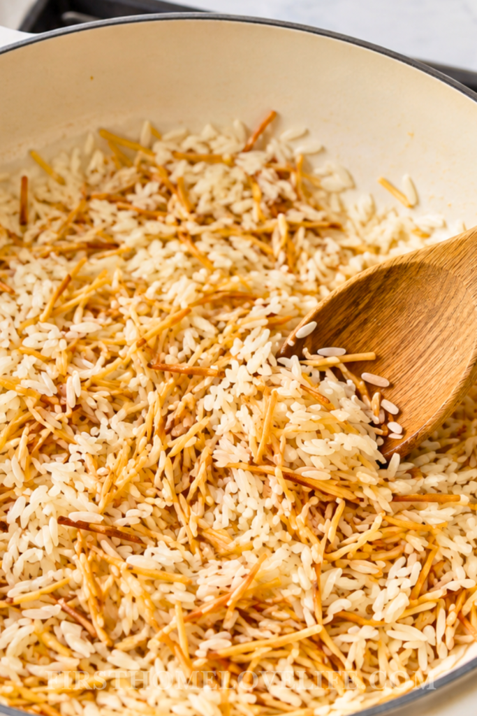 Rice and vermicelli toasting in a sauté pan with butter for homemade Rice-A-Roni.